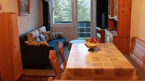 Una sala acogedora con un sofá, una mesa de comedor y una zona de cocina.