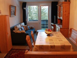 A cozy living room with a sofa, a dining table, and a kitchen area. - Haus Seewaldweg 309 Appartement/Fewo,  , 3-Bettwohnung 3-Bettwohnung by Interhome (Arosa)