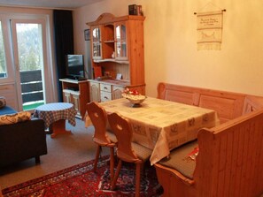 A cozy dining area with a table, chairs, and a bench. There is a television and a cabinet in the background. - Haus Seewaldweg 309 Appartement/Fewo,  , 3-Bettwohnung 3-Bettwohnung by Interhome (Arosa)