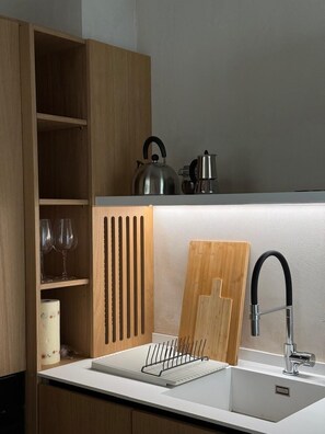 Eine moderne Küche mit weißer Arbeitsplatte, einem Spülbecken und Holzschränken.