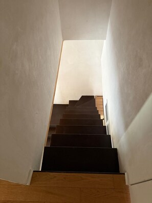 Eine Treppe, die zu einer höheren Etage führt, mit Holzboden und Geländer.