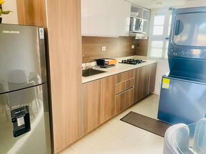 A modern kitchen with a refrigerator, stove, and cabinets. - Cozy Studio Apt. in charming Cartagena with AC (Cartagena)