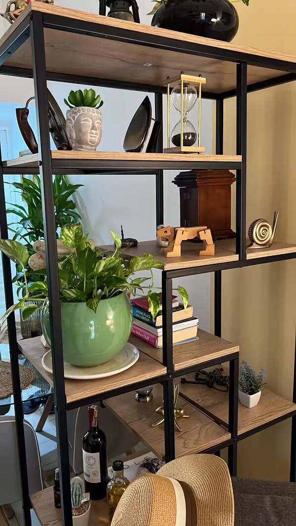 Une étagère en bois à plusieurs niveaux, agrémentée de divers objets décoratifs et de plantes.