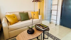 En stue med sofa, sofabord, gulvlampe og bogreol.