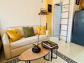 Ein Wohnzimmer mit Sofa, Couchtisch, Stehlampe und Bücherregal.