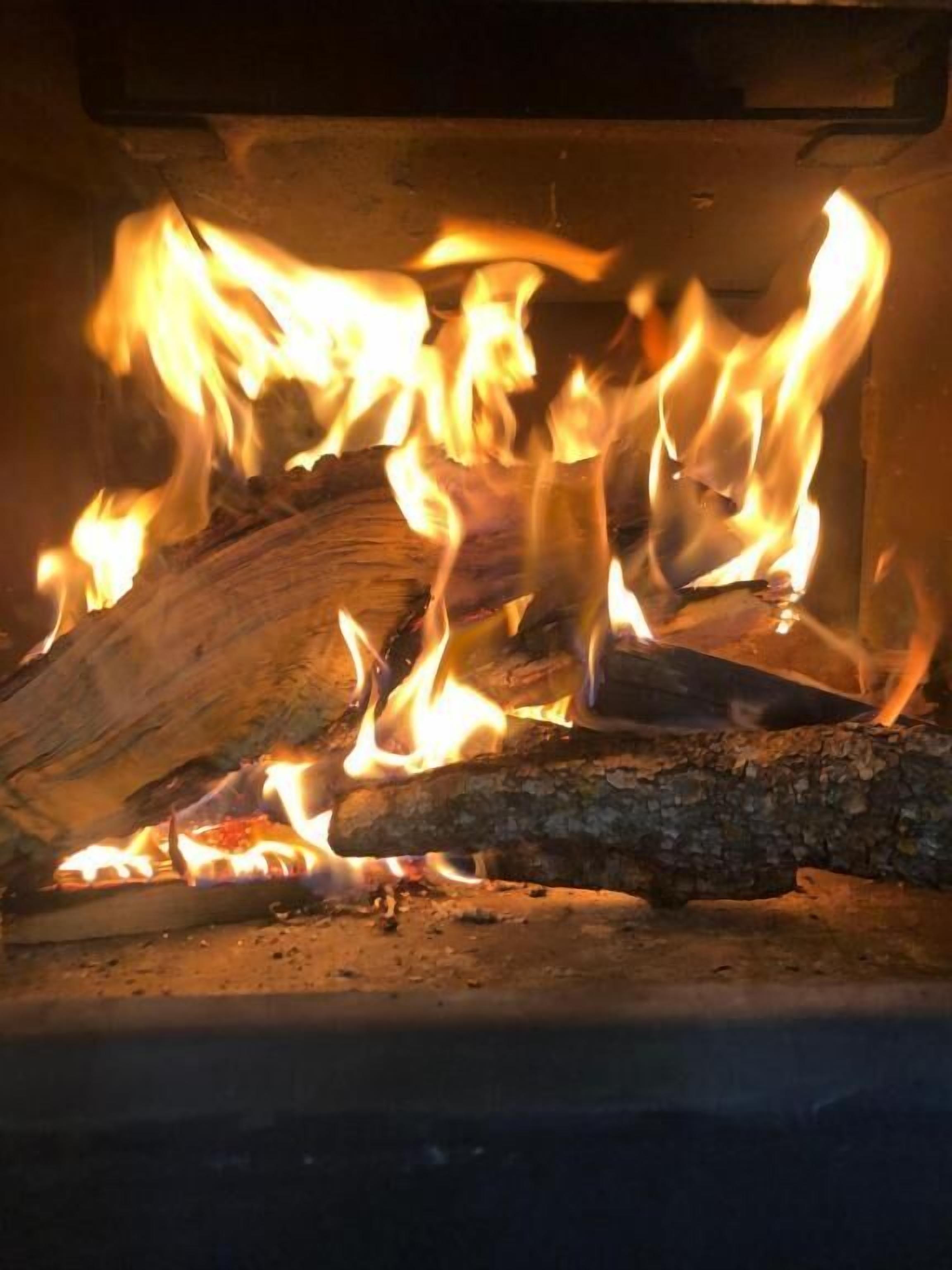 A fireplace with burning logs and flames.
