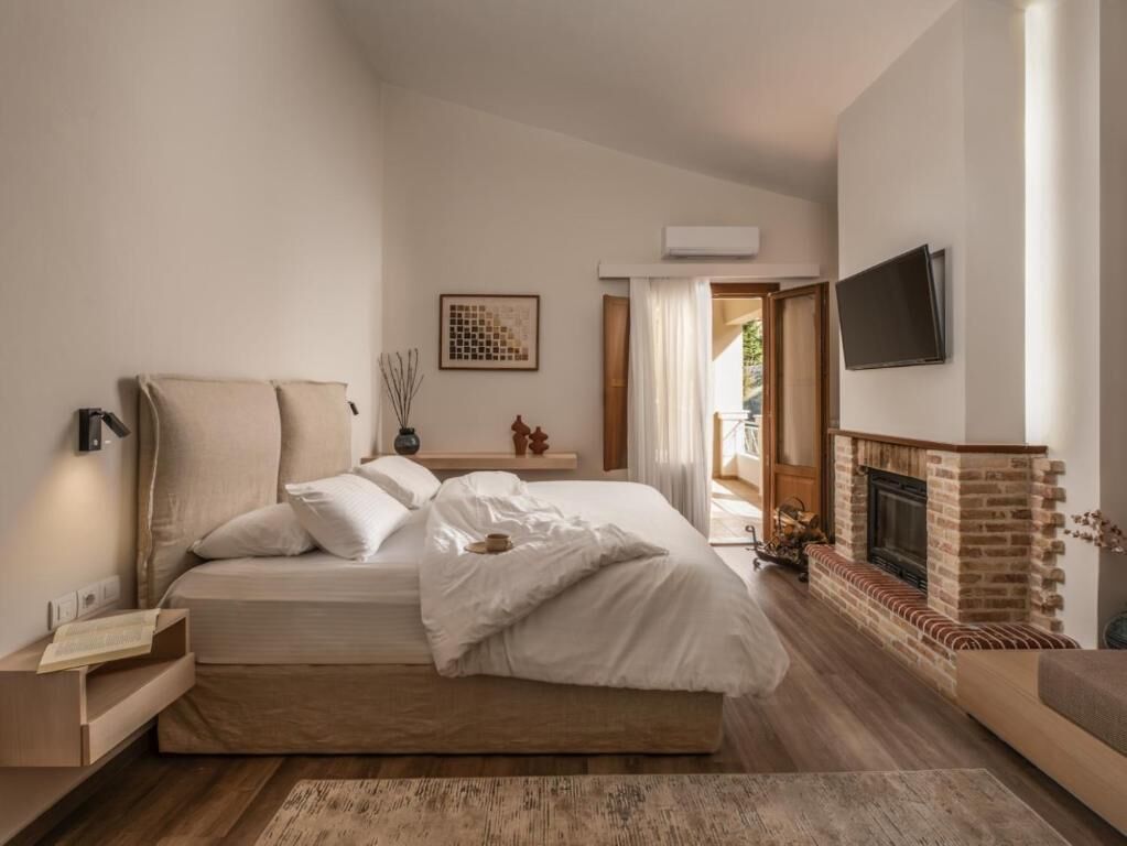 Un dormitorio con cama, mesita de noche, lámpara y chimenea.
