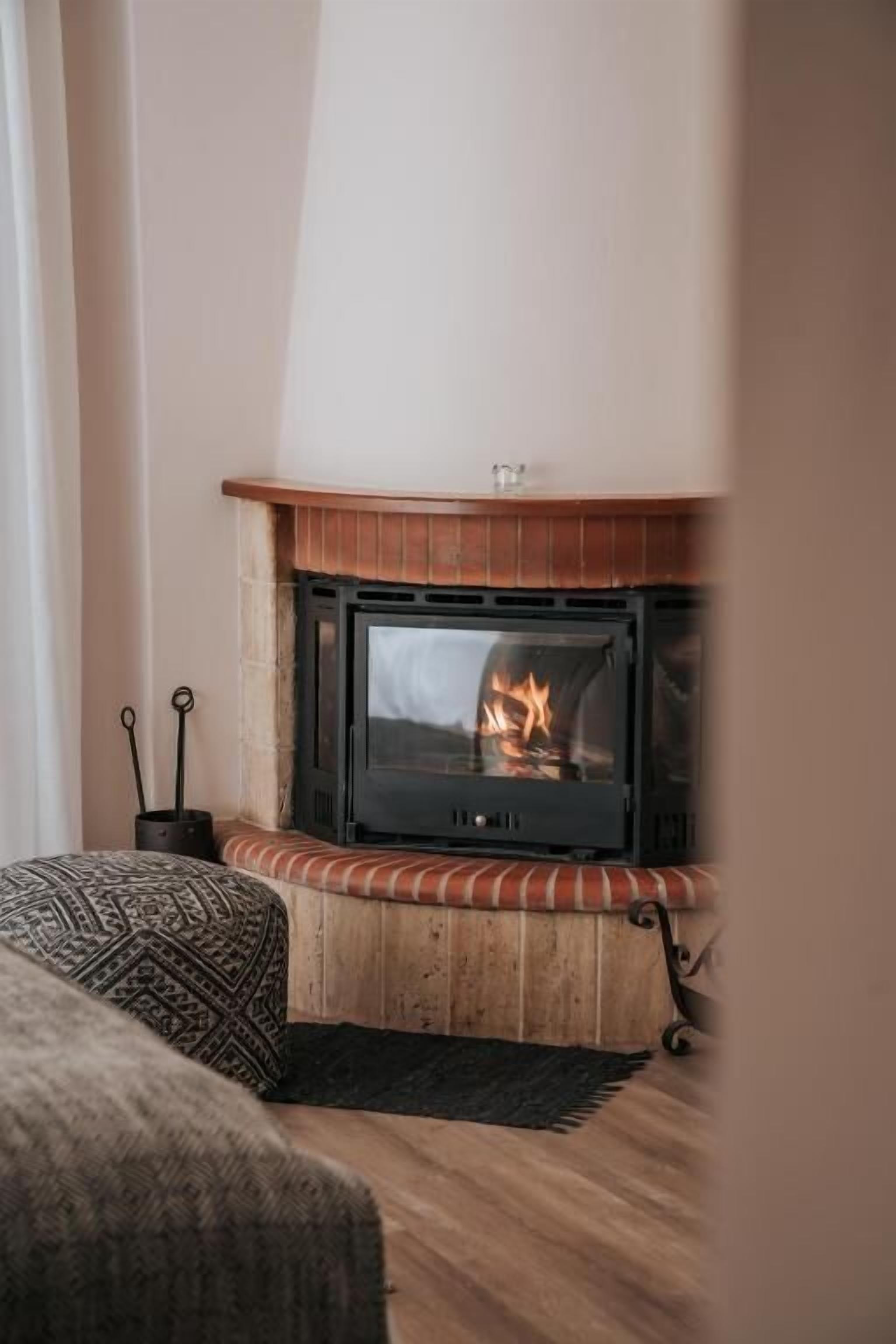 Una habitación acogedora con chimenea, un banco y una alfombra.