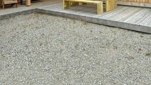A wooden building with a grassy roof, a gravel patio, and a wooden bench. - High ceilings with a view of the ski slopes (Hovden)