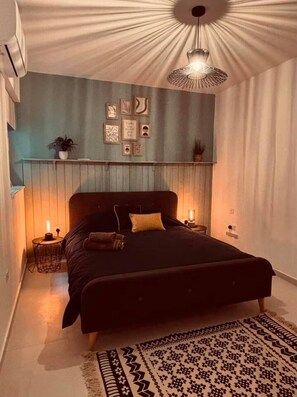 Ein Schlafzimmer mit Bett, Nachttischlampen, einem Wandregal mit Dekoration und einem einzigartigen Deckenscheinwerfer.