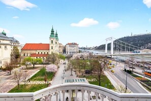 Blick auf eine Stadtlandschaft mit einem markanten Gebäude mit Gründach und einer Brücke im Hintergrund.