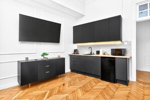 A modern kitchen with a herringbone wood floor, black cabinetry, and a built-in microwave. - Breathtaking River & Hill Views in the Heart of Budapest – 619 (Budapest)