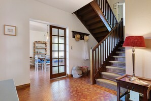 A staircase with a wooden handrail and a red lamp on a table. - Villa Oléandre with Large Private Pool, Chassiers Ardèche (Chassiers)