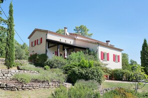 A two-story house with a stone wall in front, surrounded by greenery. - Villa Oléandre with Large Private Pool, Chassiers Ardèche (Chassiers)