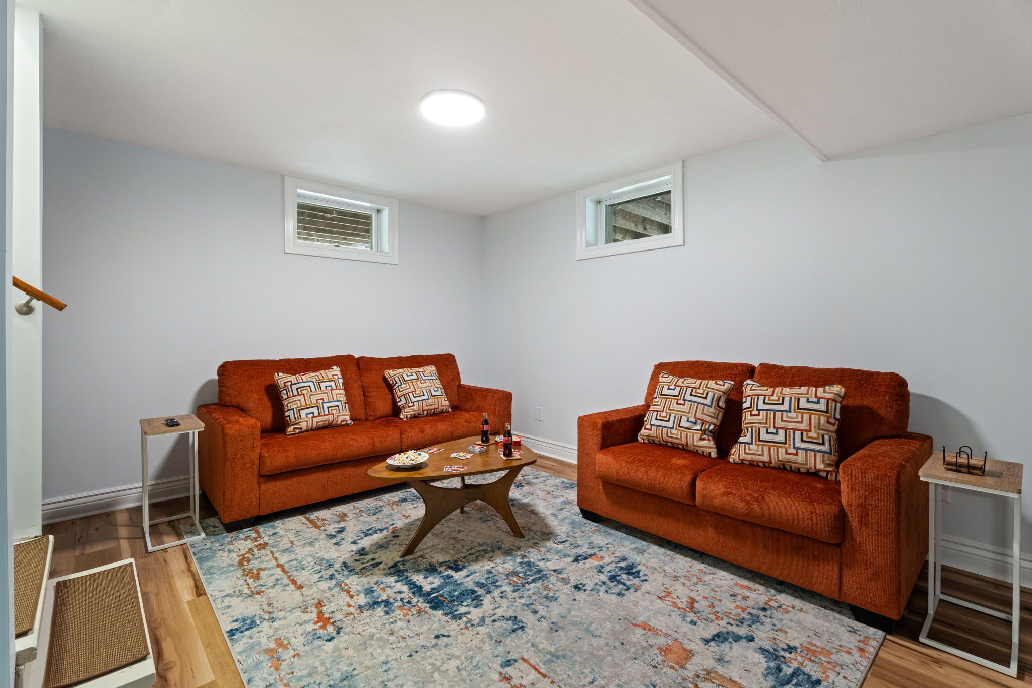 A living room with two sofas, a coffee table, and a patterned rug.