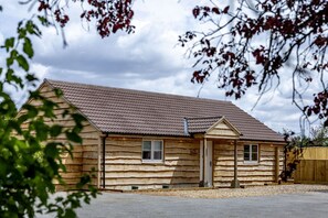 Eine eingeschossige Blockhütte mit Satteldach, einer Haustür und zwei Fenstern.
