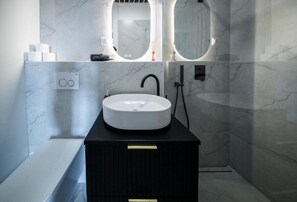 A modern bathroom with a white sink, black faucet, and two round mirrors above it. - Where the Danube Meets Downtown: Exclusive Scenic Suite – 536 (Budapest)