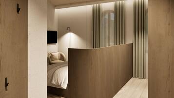 Ein modernes Interieur mit einer geschwungenen Trennwand, einem Bett mit weißer Bettwäsche, einer Stehlampe und einem an der Wand befestigten Fernseher.