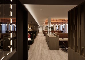 Un interior moderno con una barra central, zonas de estar y una escalera visible que conduce a un nivel superior.