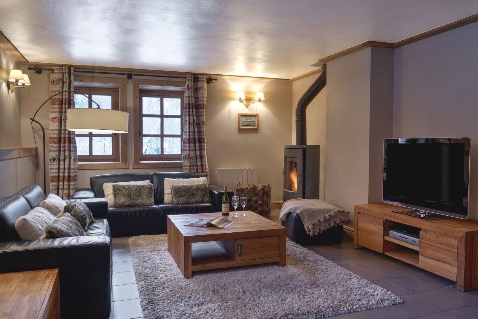 A cozy living room with a sofa, a coffee table, a TV, and a fireplace.