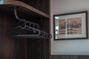 A wooden wall with a metal coat rack and a framed historical map. - Captain Stam Suites Athens - CityStudio (Athina)