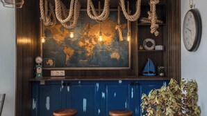 A bar area with a world map, nautical-themed decor, and a clock. - Captain Stam Suites Athens - FamilyApartment (Athina)