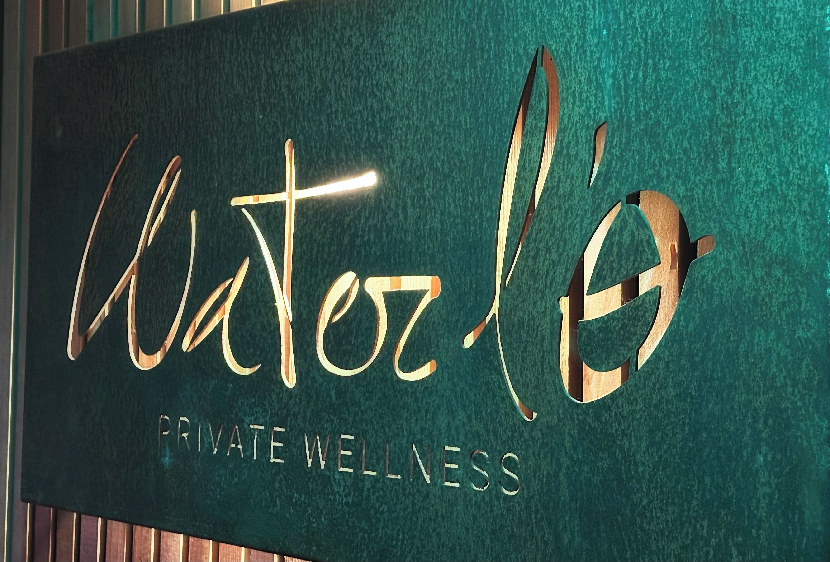 Een bord met de naam 'Waterloo' en de tekst 'PRIVATE WELLNESS', dat de naam en het soort etablissement aangeeft.