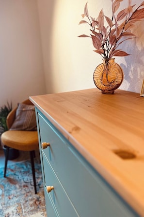 Une table en bois sur laquelle se trouve un vase contenant des plantes séchées.