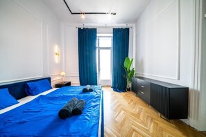 Ein Hotelzimmer mit einem Bett, einem Nachttisch, einem Heizkörper und einem Fenster mit Vorhängen.