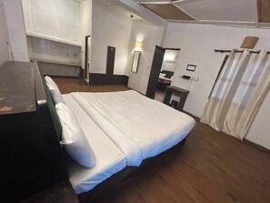 A hotel room with a bed, a desk, a chair, a wardrobe, and a bathroom. - Hotel Solpine Retreat Manali (Manali)