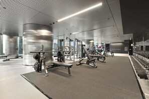 Ein modernes Fitnessstudio mit unterschiedlichen Trainingsgeräten, darunter Bänke und Kraftgeräte.