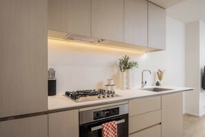 Eine moderne Küche mit Gasherd, Backofen und integriertem Spülbecken.