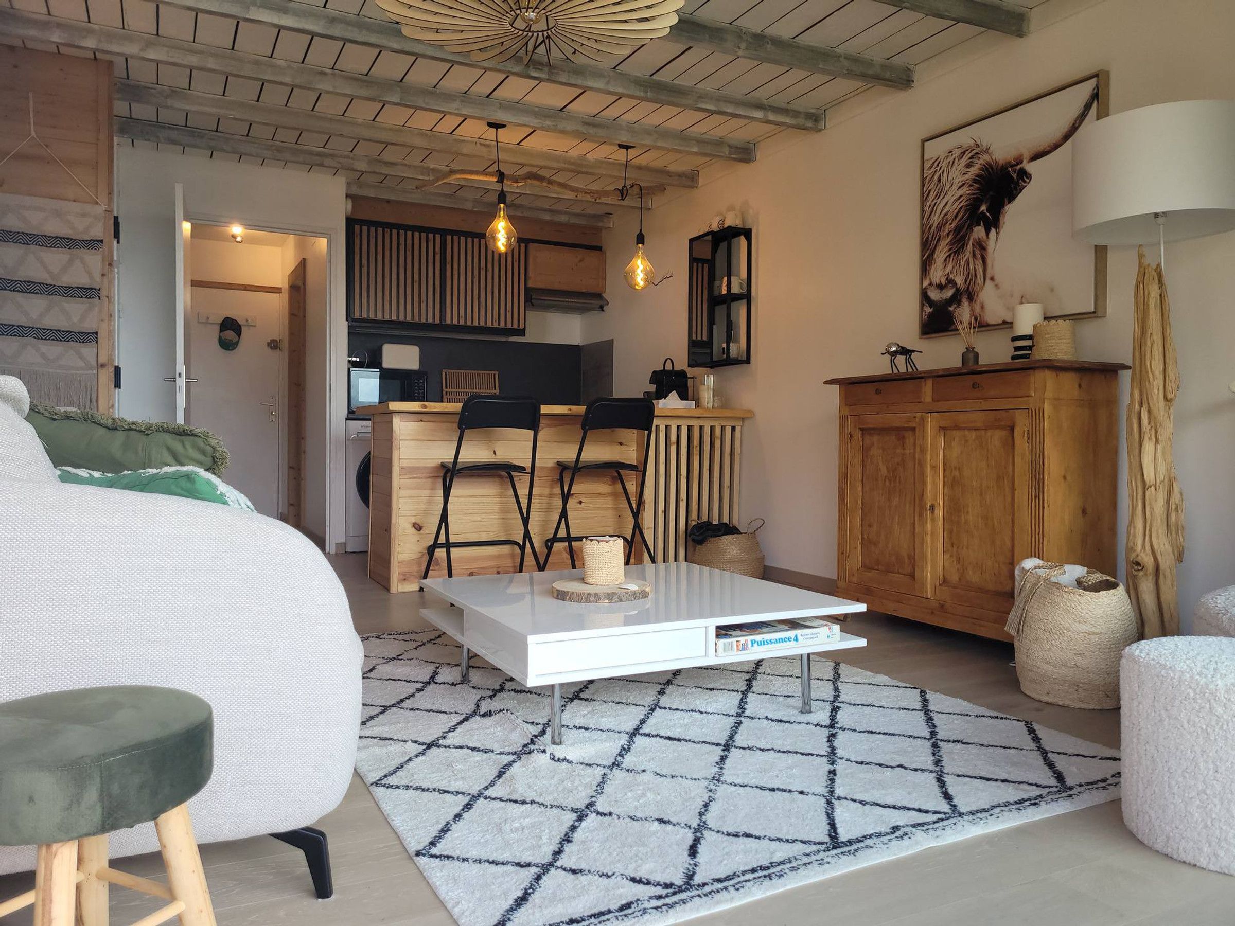 Un espace de vie moderne comprenant un canapé, une table basse et un coin repas avec des chaises.