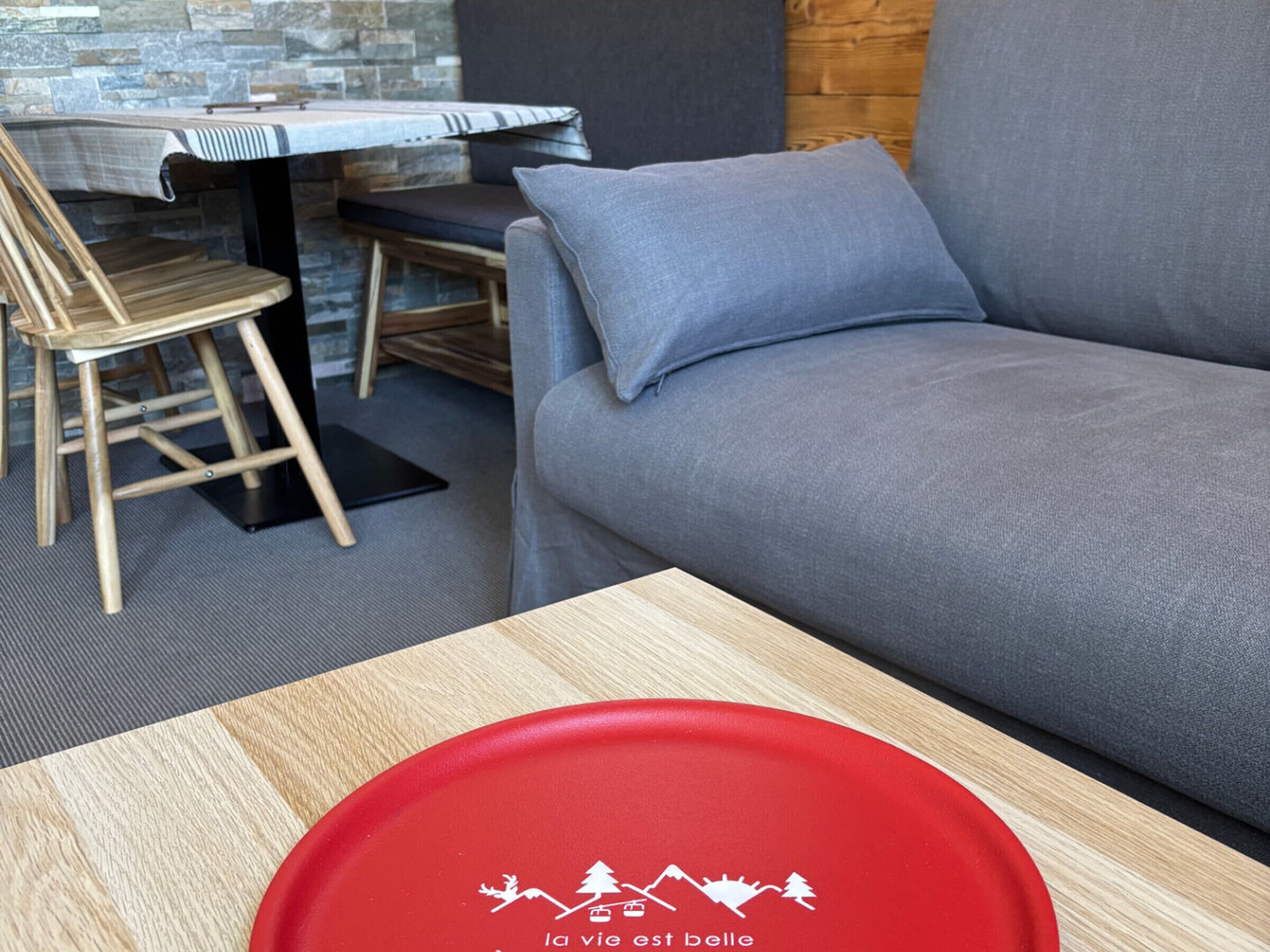 Un espacio moderno para relajarse con sofá, mesa de comedor y una silla de madera.