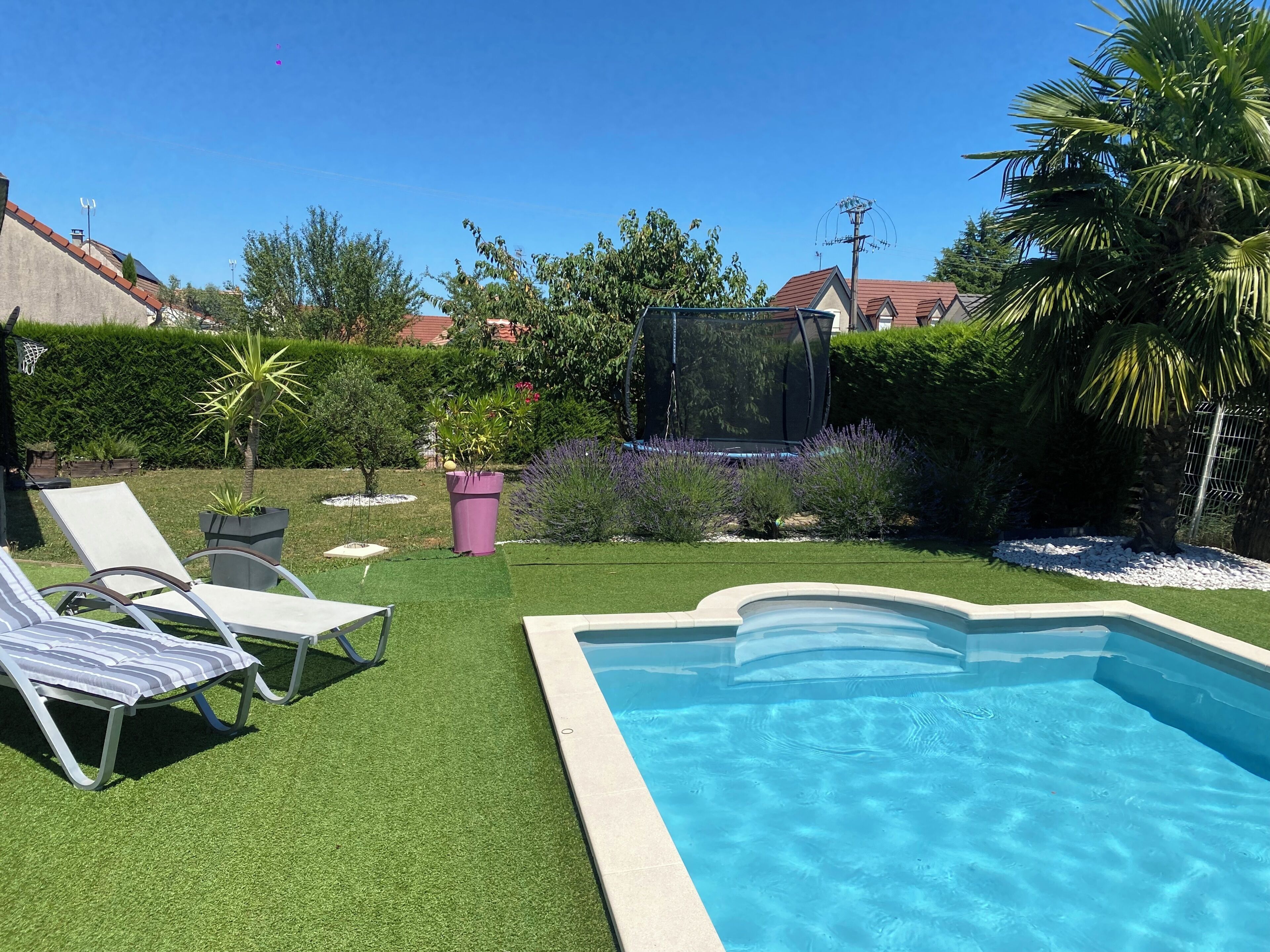 Un pati amb piscina, gespa artificial i unes quantes gandules.