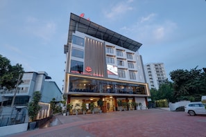Een modern hotel met een glazen gevel, een opvallend bord en een aangelegde entree.
