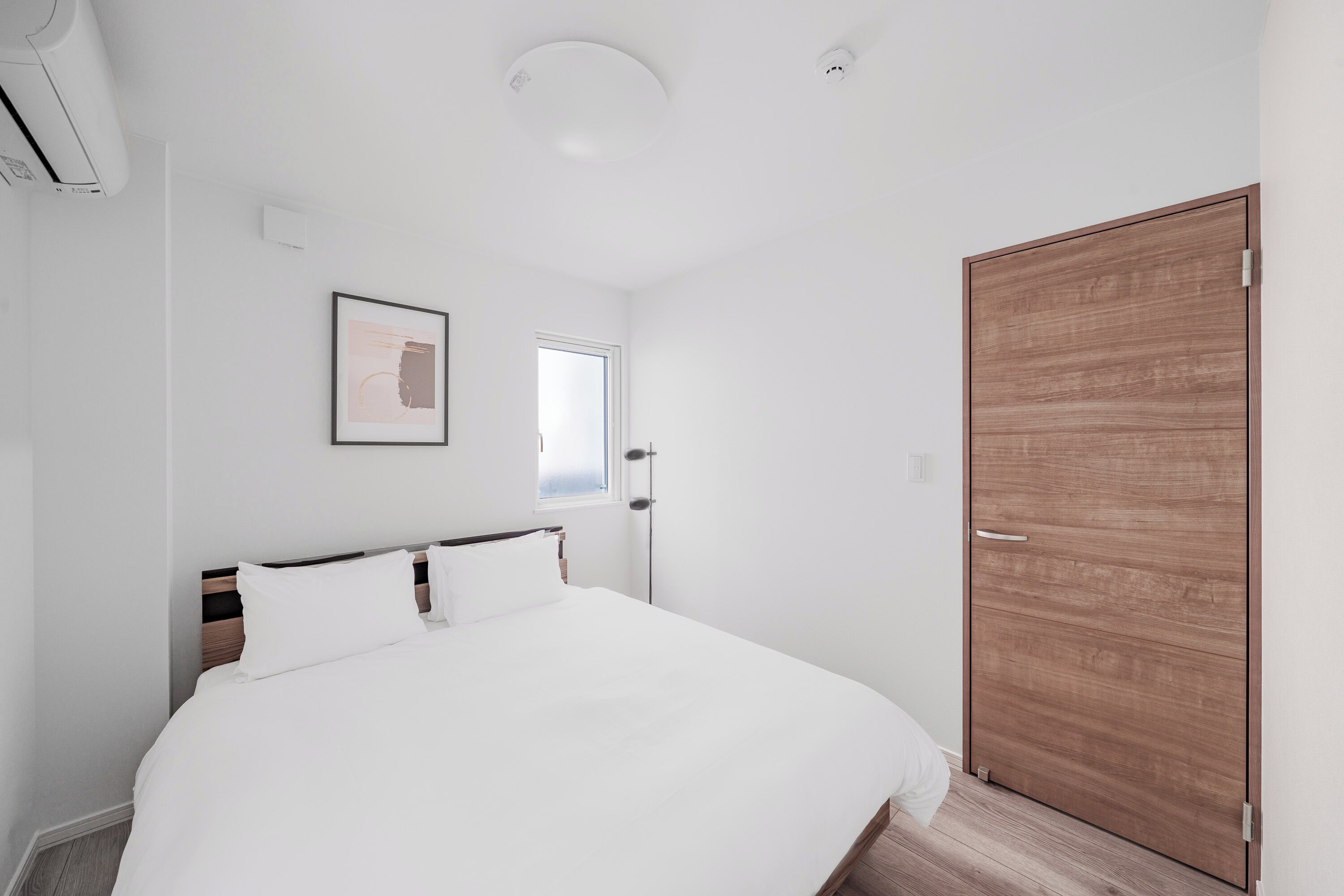 Une chambre à coucher avec un lit, une porte et une fenêtre.