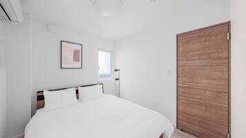 Une chambre à coucher avec un lit, une porte et une fenêtre.