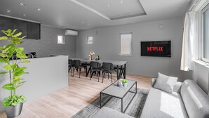 Un espace de vie moderne comprenant un coin repas, un canapé, une table basse et une plante.