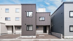 Un immeuble résidentiel moderne à plusieurs étages, doté d’un toit plat, de nombreuses fenêtres et d’une antenne parabolique.