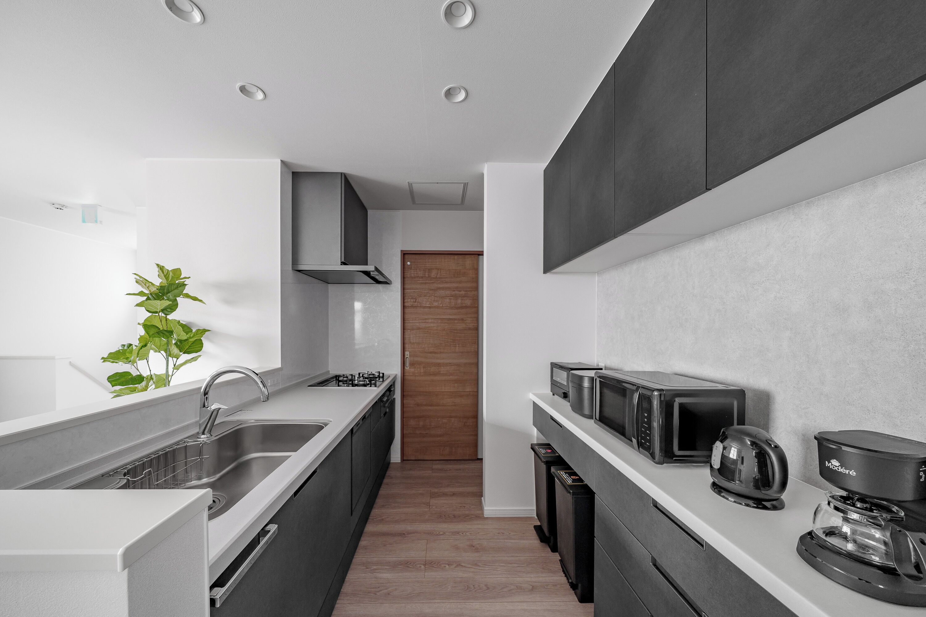 A modern kitchen with a central island, stainless steel appliances, and a built-in oven.