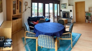 A dining area with a round table, blue tablecloth, and checkered chairs. - Casa Surselva Whg Marti Appartement/Fewo, Bad, WC, 2 Schlafräume by Interhome (Savognin)