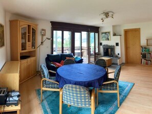 A dining area with a round table, blue tablecloth, and checkered chairs. - Casa Surselva Whg Marti Appartement/Fewo, Bad, WC, 2 Schlafräume by Interhome (Savognin)