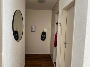 A hallway with a mirror, a framed picture, and a door with a towel hanging on it. - Tga Crap Alv Appartement/Fewo, Dusche, WC, 2 Schlafräume by Interhome (Savognin)