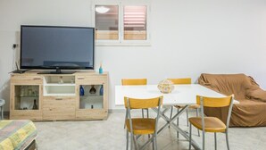 A room with a television on a wooden cabinet, a dining table with chairs, and a sofa. - EmyHouse54 - Small Villa with Pool (Martina franca)
