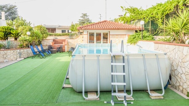 An outdoor swimming pool with a ladder, surrounded by a stone wall and greenery. - EmyHouse54 - Small Villa with Pool (Martina franca)