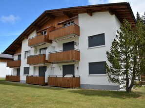Ein mehrstöckiges Gebäude mit hölzernen Balkonen und einer flachen Dachfläche.