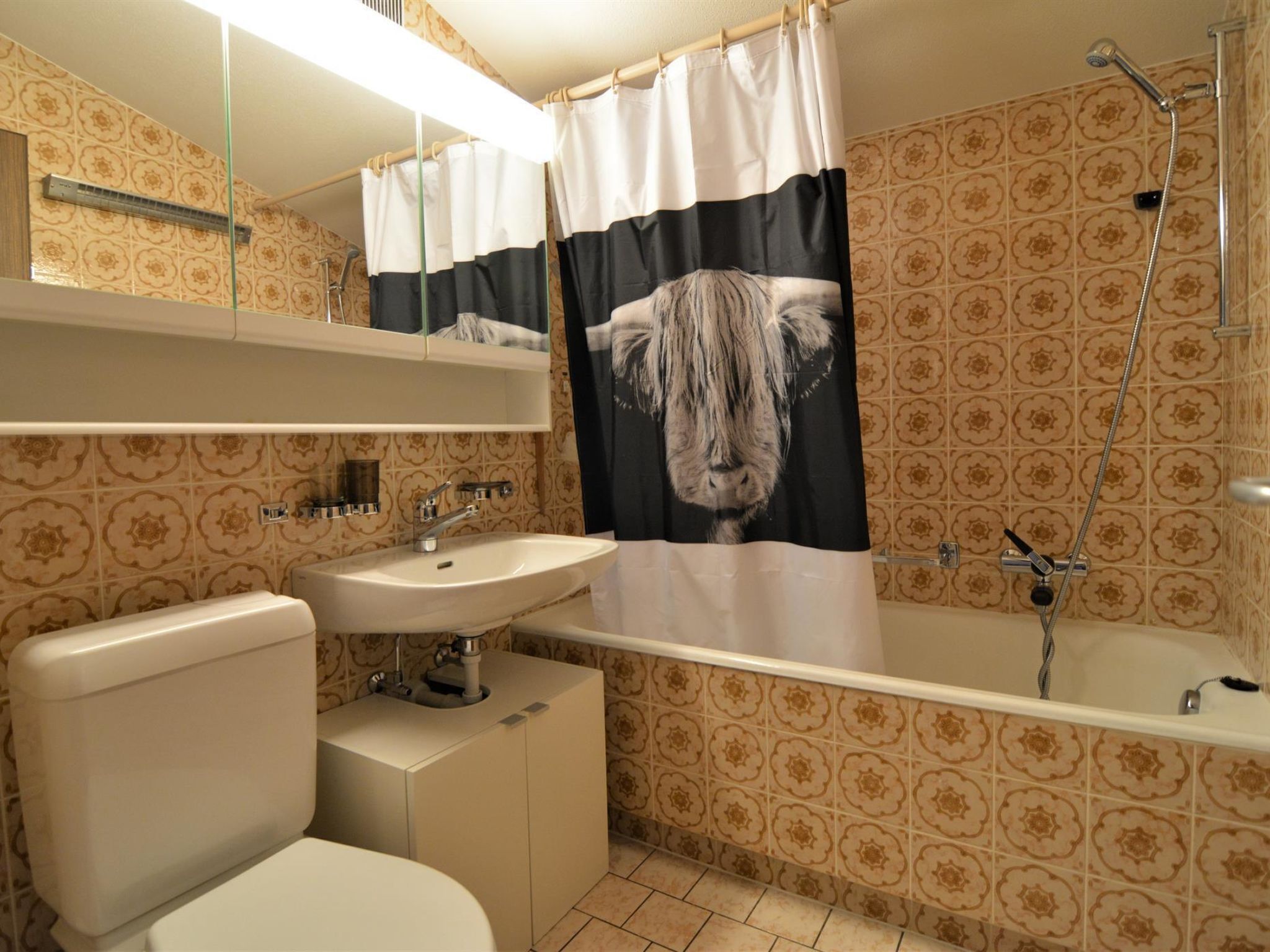 A bathroom with a toilet, sink, and bathtub.
