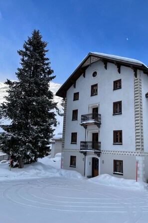 Ein mehrstöckiges Gebäude mit einem verschneiten Balkon, umgeben von Schnee.
