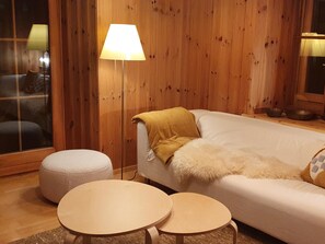 Ein gemütliches Zimmer mit einem Bett, einer Lampe und zwei kleinen Tischen.